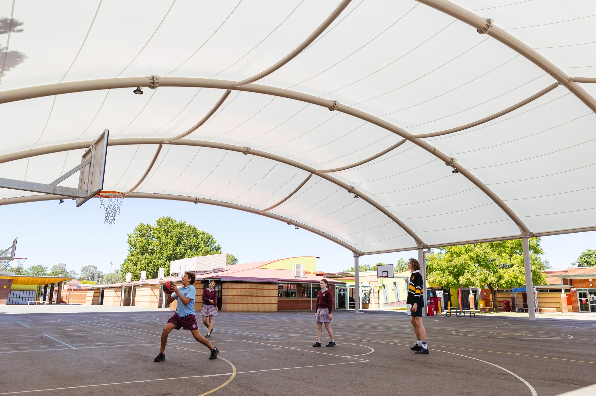Photo of students playing basketball under the cover at Galen Catholic College. 