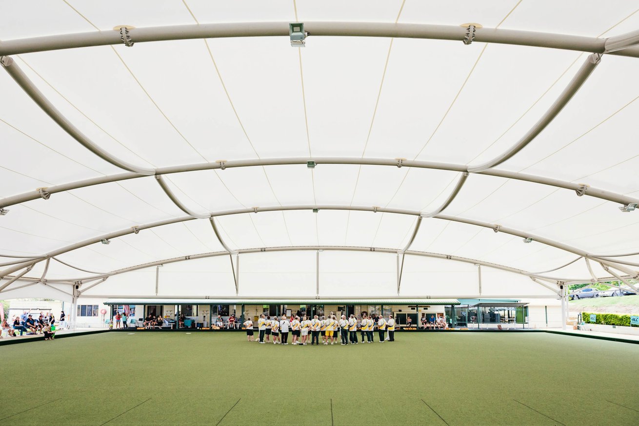 Community event under a new canopy with people speaking at a podium during an opening ceremony.