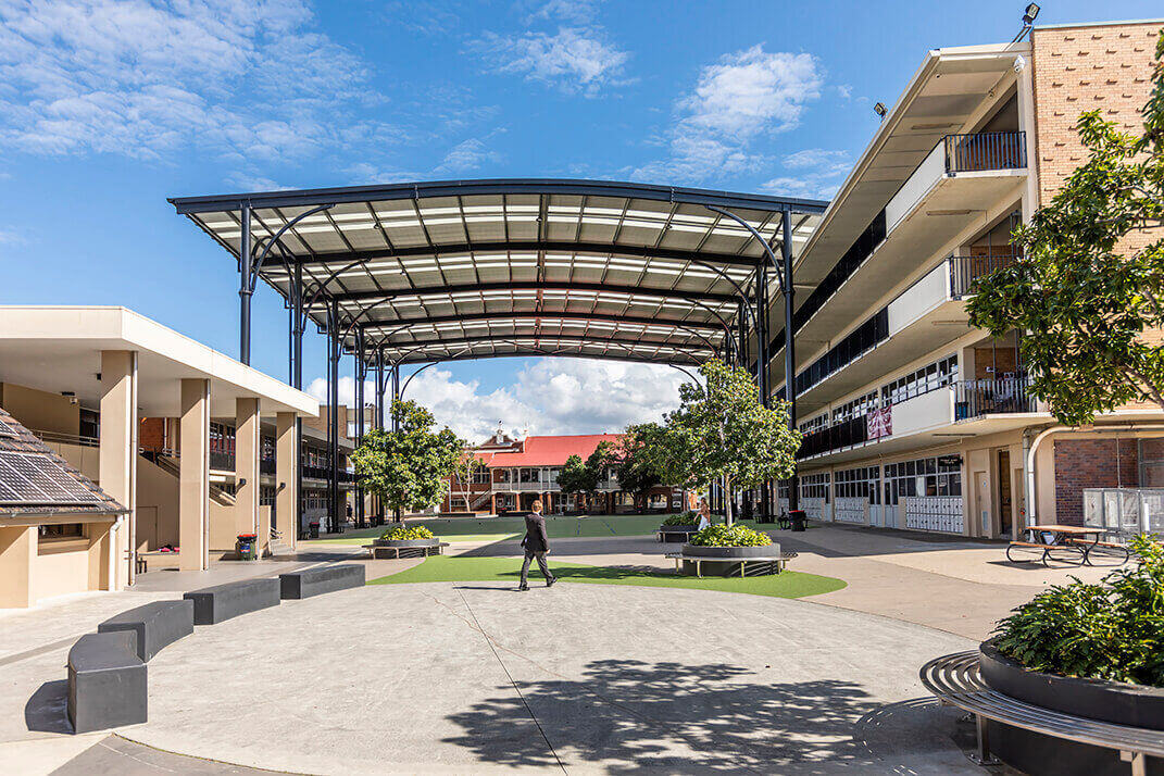 Large central courtyard shaded by uniform white sails supported by steel poles.