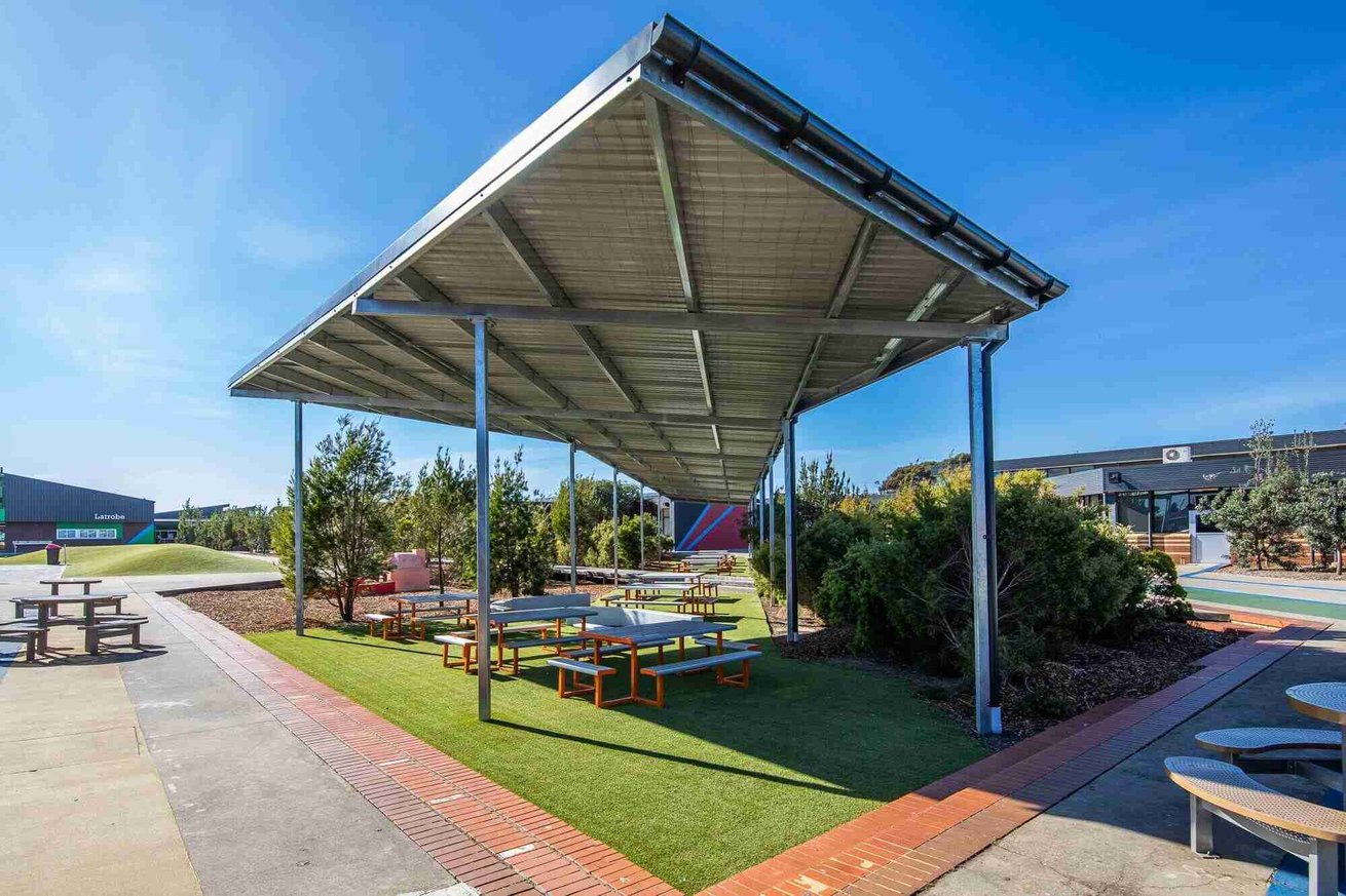 Open courtyard featuring shade sails over concrete seating areas.