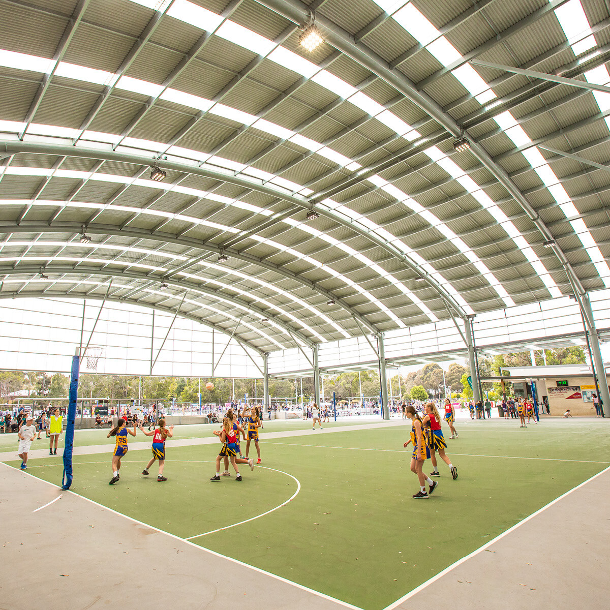 Netball players playing on a covered netball court