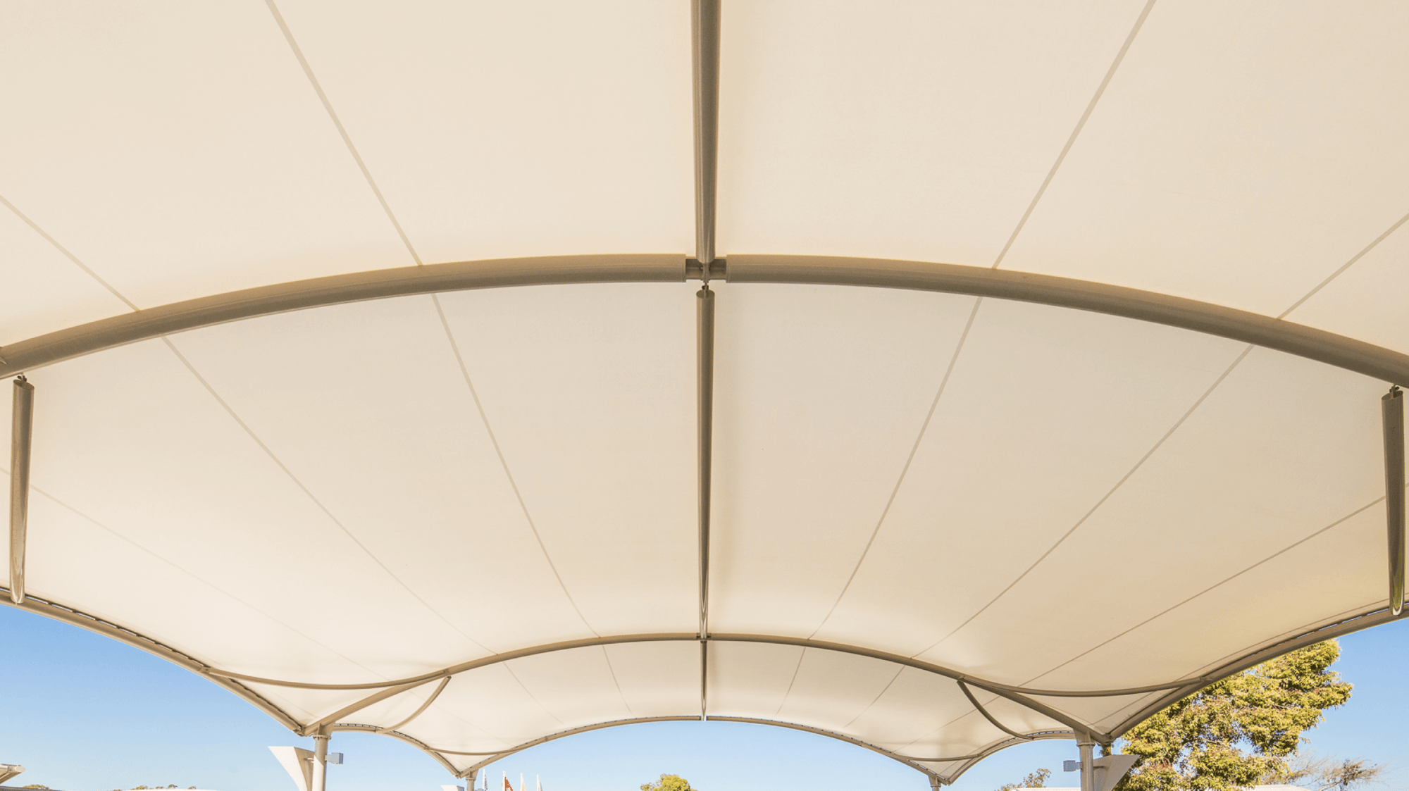 Photo of the underside view of a tensioned fabric canopy with its steel support frame.