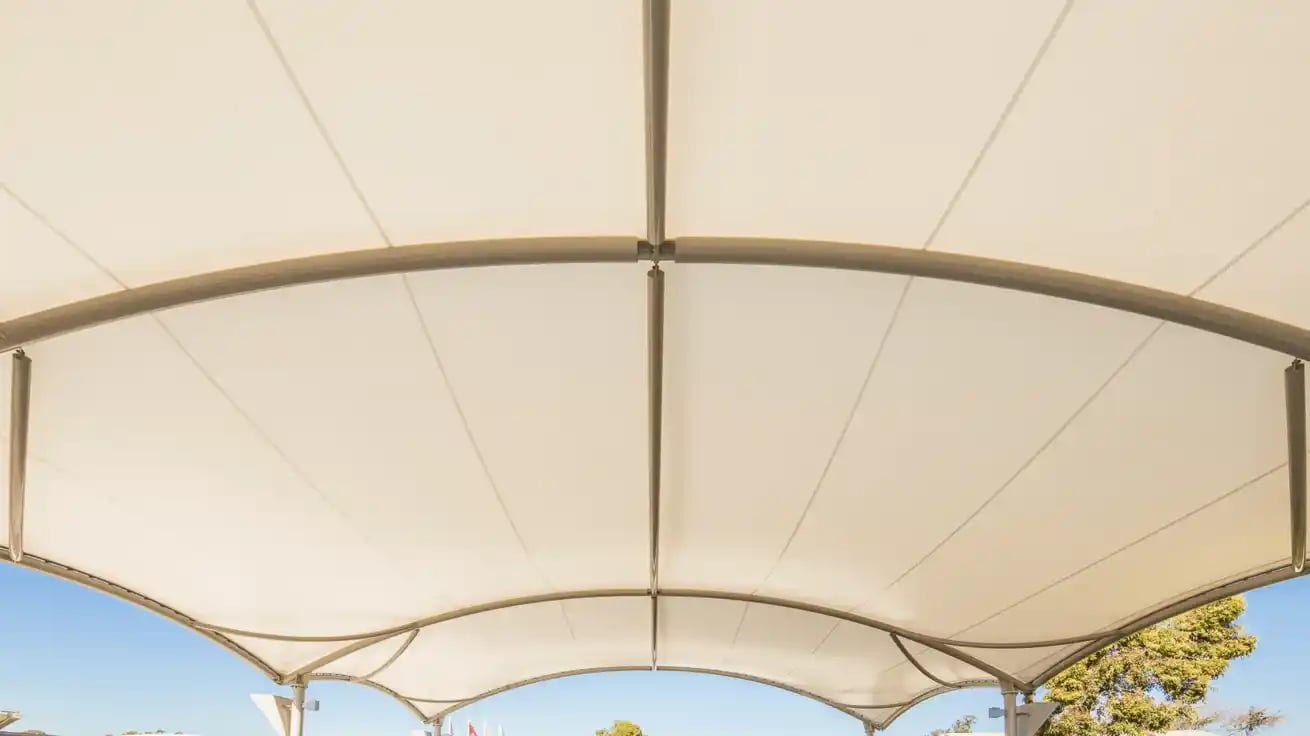 Underside view of a tensioned fabric canopy with its steel support frame.